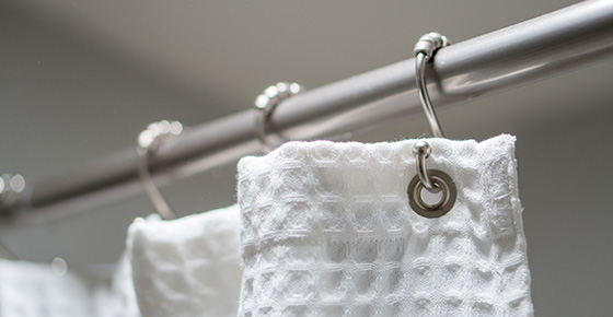 A White Curtain Hanging From a Shower Curtain Liner