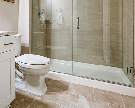 Sleek New Shower Liner Panels With a Glass Door After Tub-to-Shower Conversion